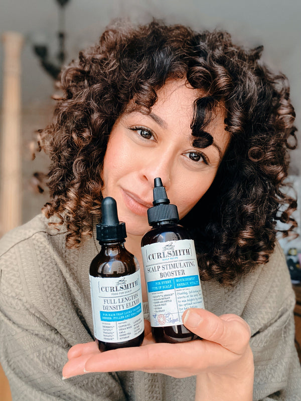 Woman presenting Curlsmith scalp products
