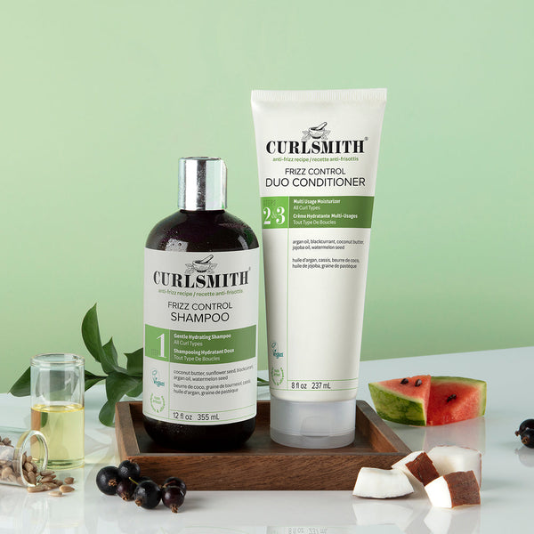 Two Curlsmith frizz control products on a green background