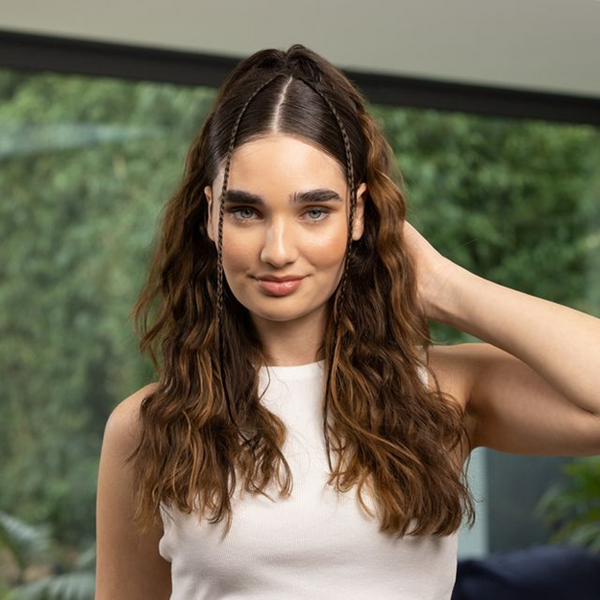 Woman with curly hair and two braids on a plant background