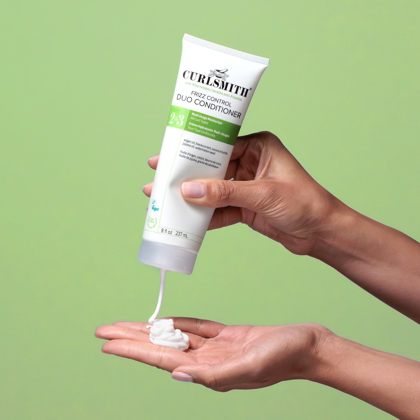 Curlsmith hair care product being applied to a hand against a green background, Klicken, um zu vergrößern