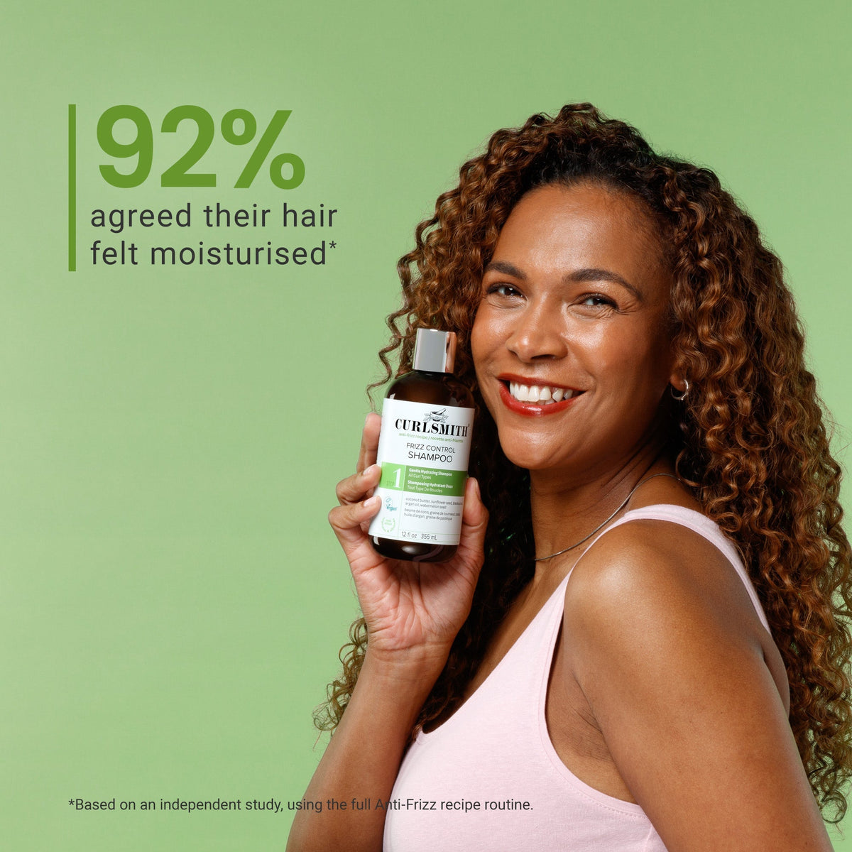 Woman holding a bottle of Curlsmith shampoo with a green background and text about hair moisturization.