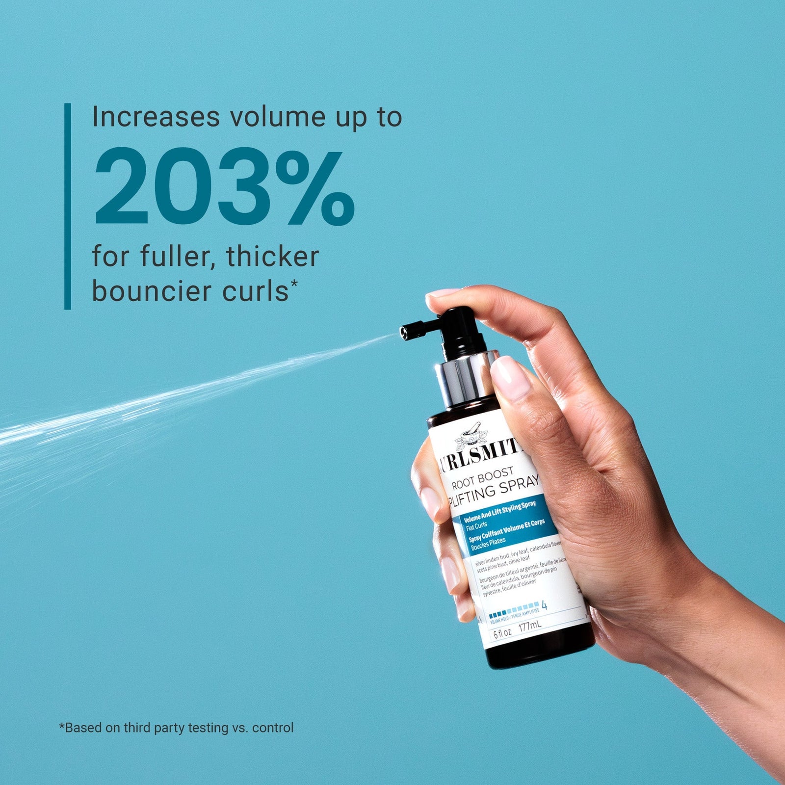 Hand holding a bottle of Ruskite Root Boost Texturizing Spray against a blue background