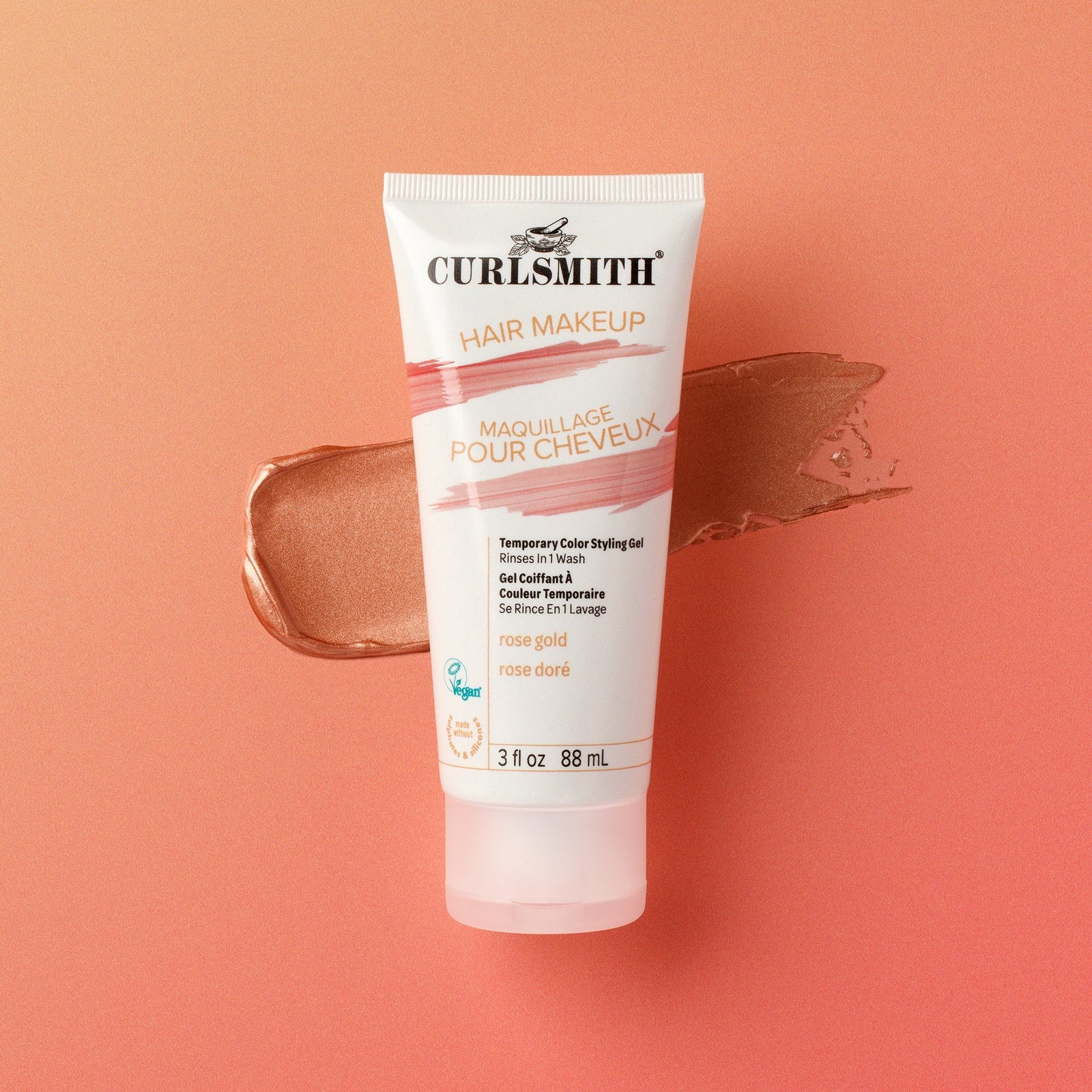 Curlsmith hair makeup tube on a peach background