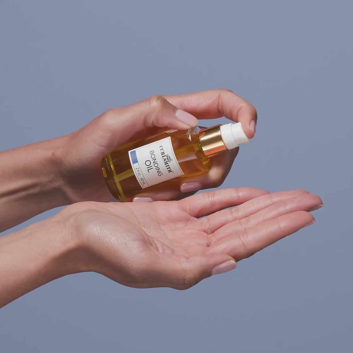 Hand holding Curlsmith Bonding Oil