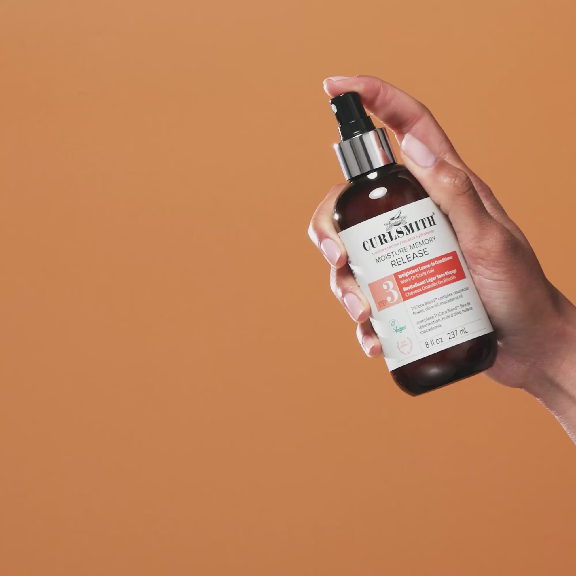 Hand holding Curlsmith Moisture Memory Release